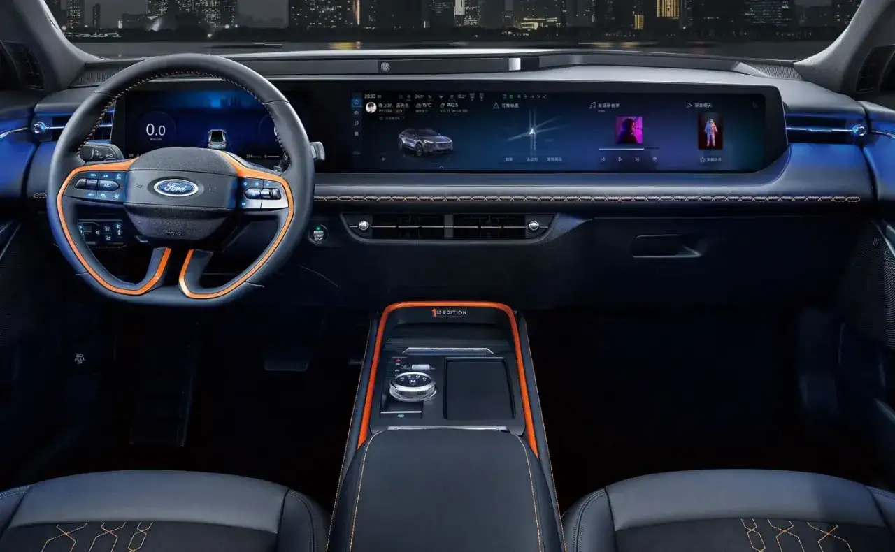 Wnętrze Ford Evos z pomarańczowymi akcentami i dużym ekranem multimedialnym.