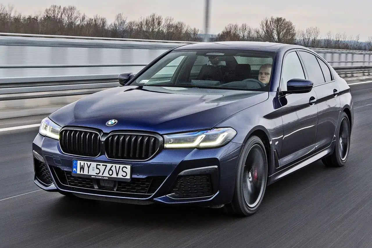 Ciemnoniebieskie BMW 520d xDrive z polskimi tablicami rejestracyjnymi jedzie po autostradzie.