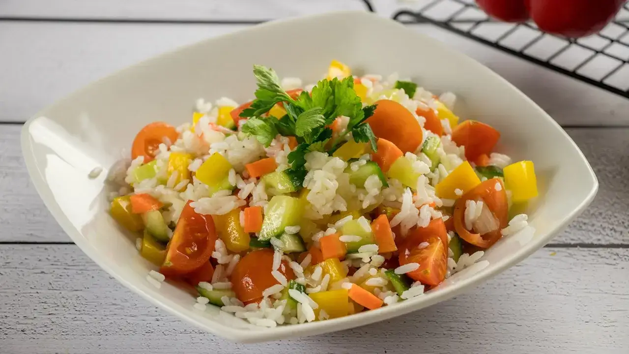 Frischer Reissalat mit Tomaten, Gurken, Paprika und Karotten. Ein leichtes und gesundes Reissalat Rezept für den Sommer.