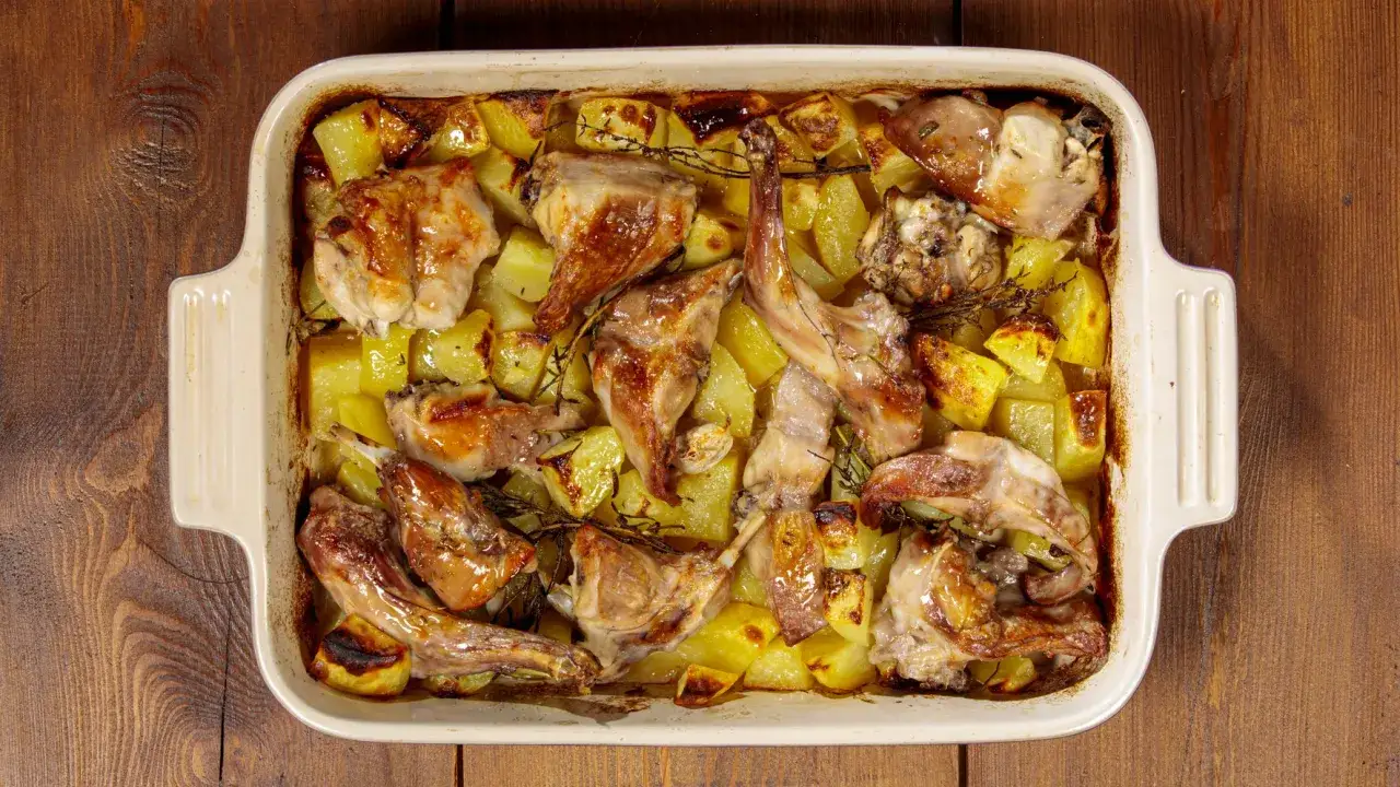 Coniglio ripieno al forno con patate, dorato e profumato, pronto per essere gustato.