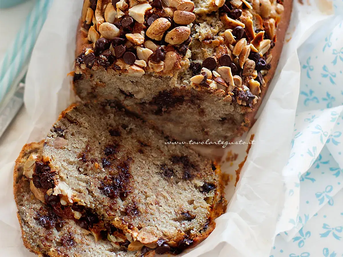 Delizioso banana bread senza uova, con gocce di cioccolato e mandorle tostate in superficie. Perfetto per la colazione o la merenda.