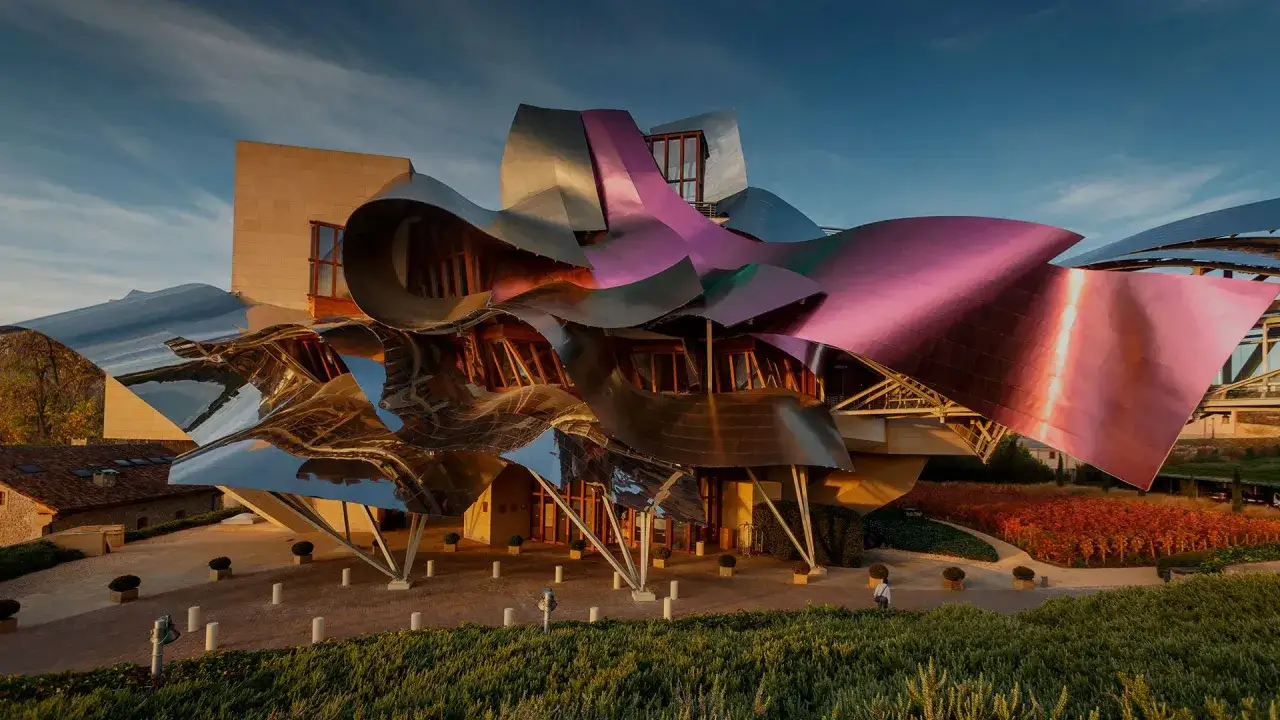 Bodegas España con arquitectura vanguardista y viñedos en otoño.