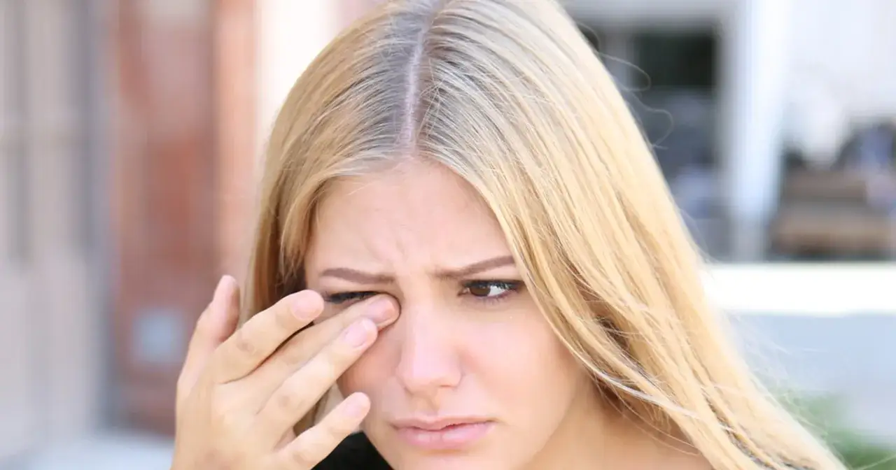 Blondynka pociera oko, jakby miała problem z widzeniem w ciemności.