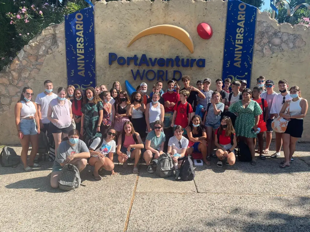 Groupe d'adolescents souriants devant le panneau 