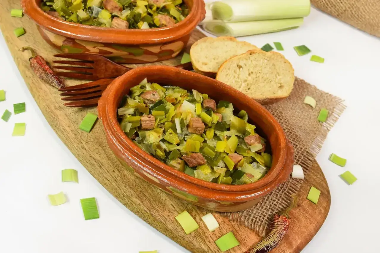 Herzhafte Lauch-Rezepte in Terrakotta-Schalen, garniert mit frischem Lauch und Brot.