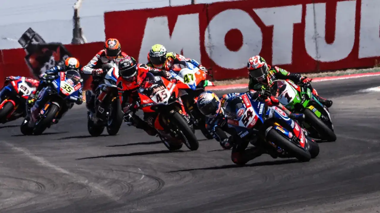 Emocionante carrera de sbk hoy. Varios pilotos compiten en una curva cerrada, inclinados al m&aacute;ximo.