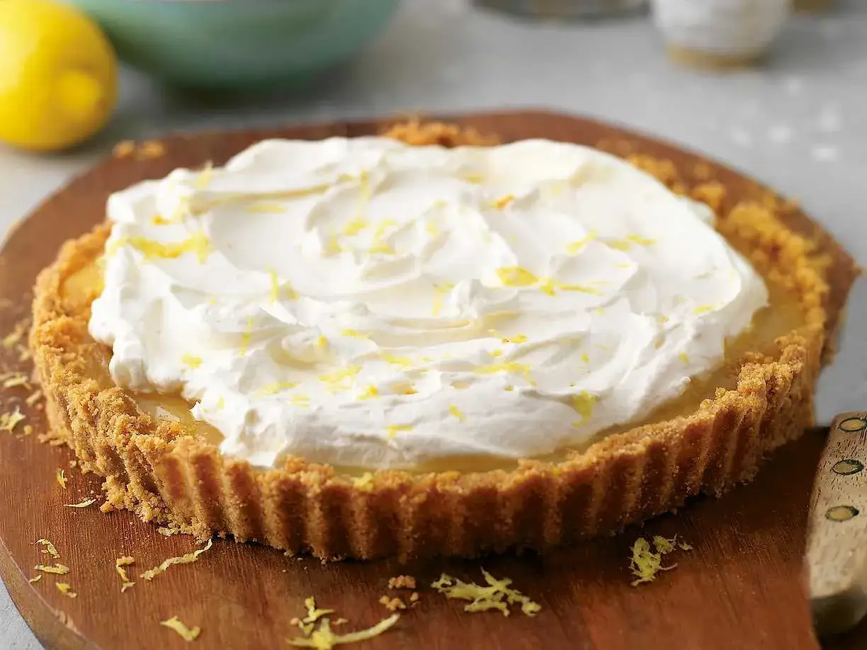 En krämig lemon key pie med vispad grädde och citronskal.