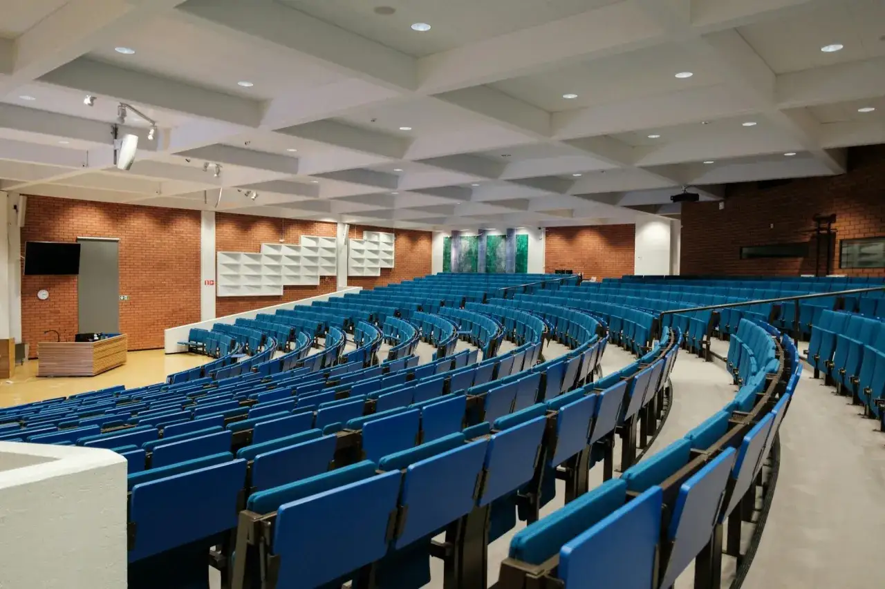 Leeres Auditorium mit blauen Sitzen, bereit f&uuml;r das Wirtschaftsrecht Studium.
