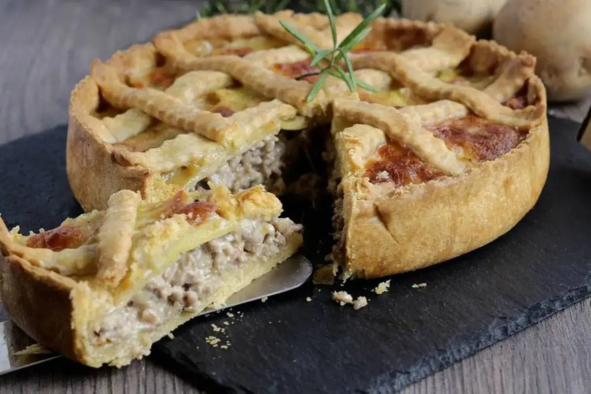 Torta salata con pasta frolla Buitoni, ripiena di carne macinata e patate, guarnita con rosmarino.