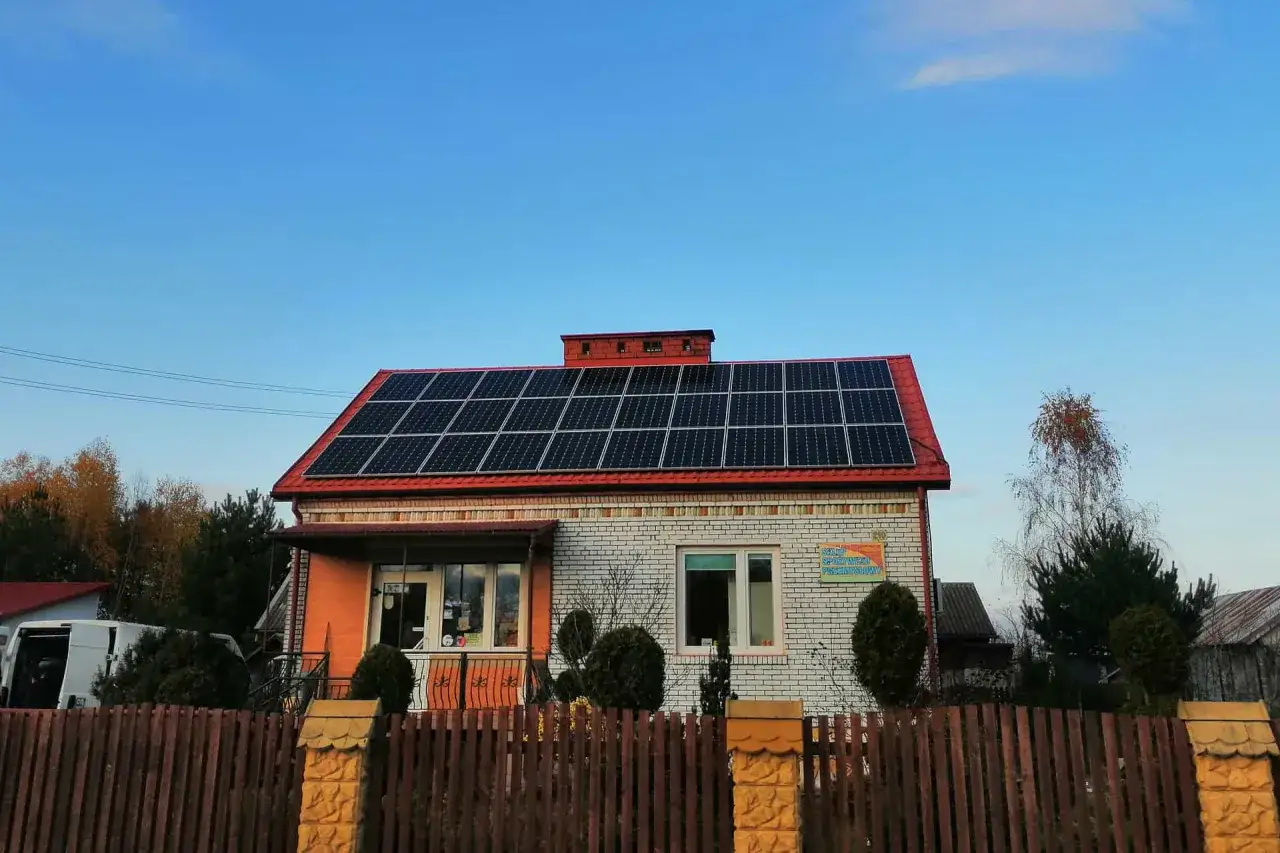 Dom z panelami fotowoltaicznymi na dachu, symbolizującymi autokonsumpcję energii.