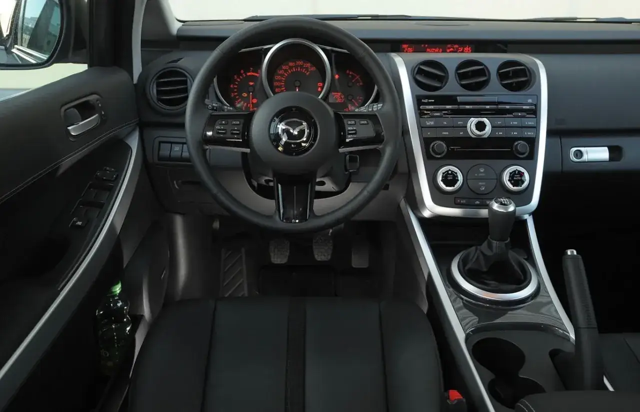 Wnętrze Mazdy CX-7 2.3 Turbo: czarna skórzana tapicerka, kierownica z przyciskami, deska rozdzielcza z radiem i nawiewami.
