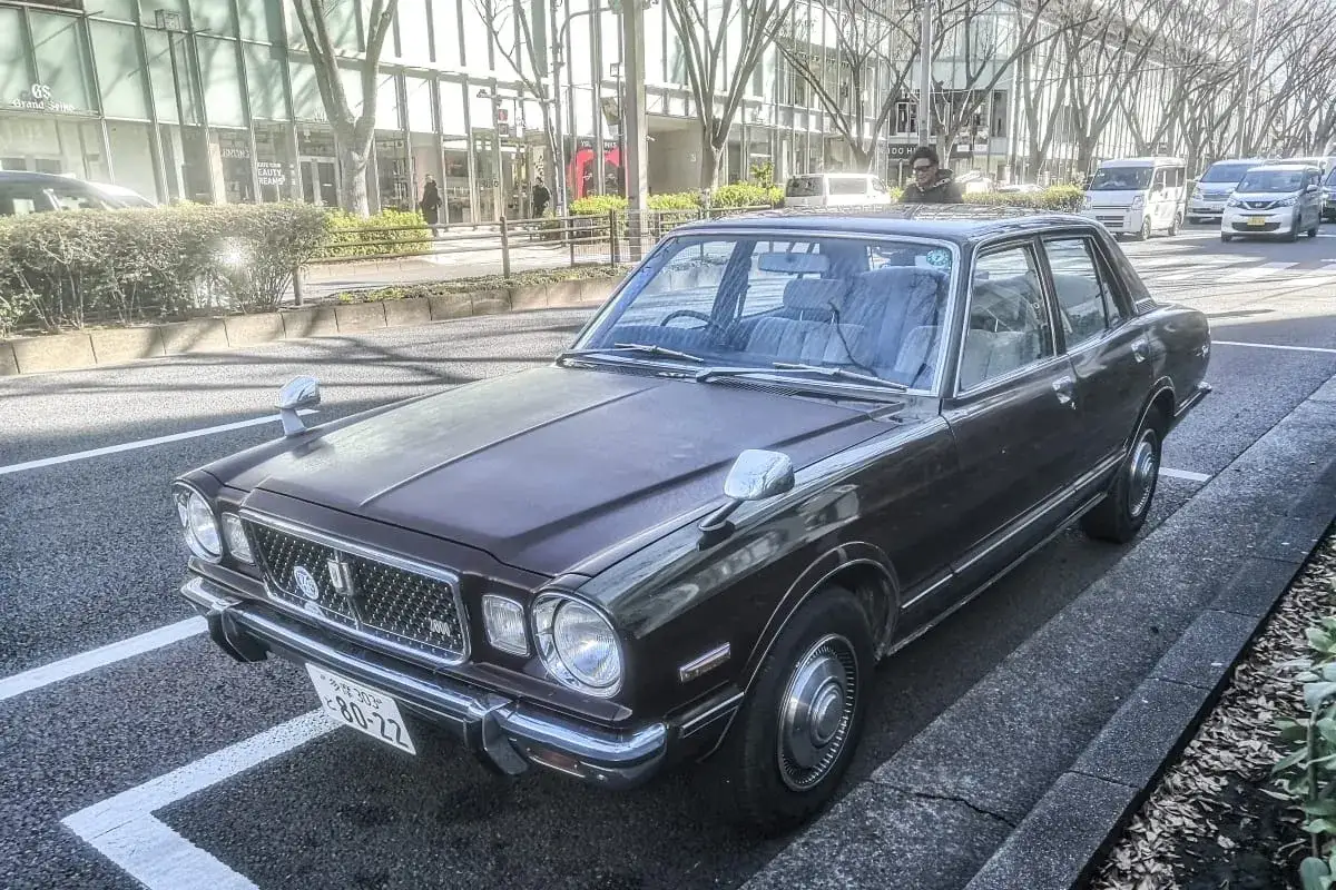 Klasyczny brązowy Toyota Mark II z lat 70. stoi na ulicy w Japonii.