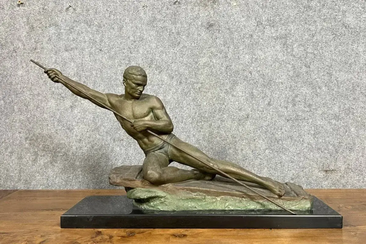 Sculpture d'un athlète en mouvement, tenant une lance. Cette pièce en bronze ou régule, prête à nettoyer, évoque la force et la détermination.