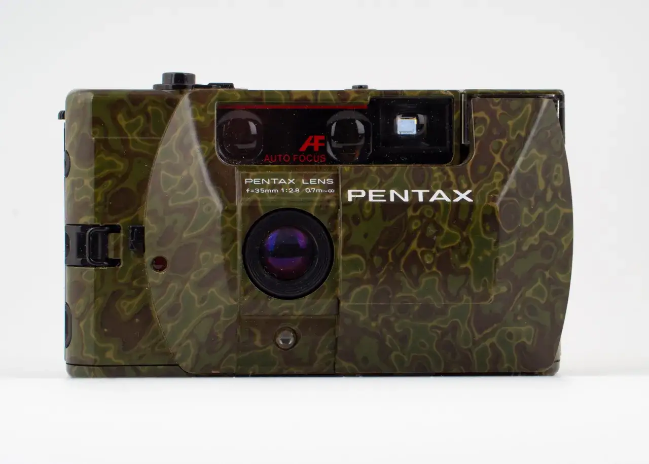 En kamouflerad Pentax PC35AF-kamera med autofokus. Perfekt för att smälta in i naturen och fånga ögonblicken.