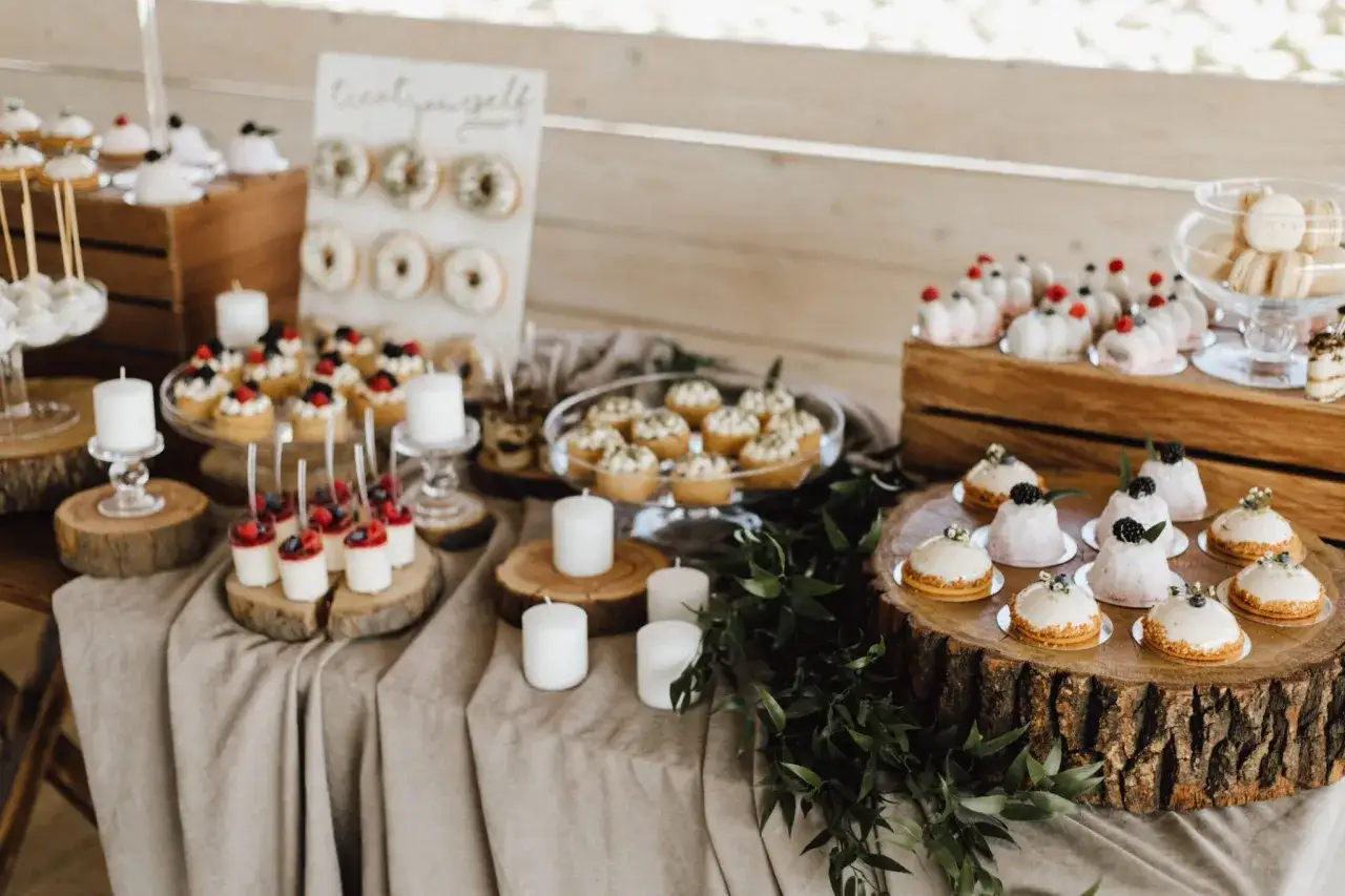 Un buffet de desserts pour un repas mariage : mini-gâteaux, donuts, macarons et verrines.