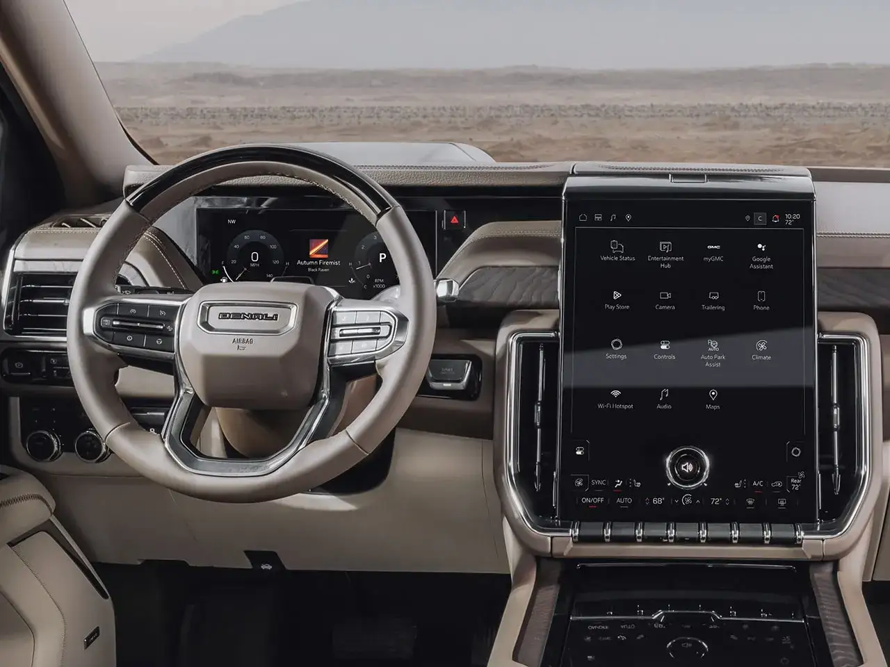 Wnętrze GMC Yukon Denali z dużym ekranem dotykowym i cyfrowymi zegarami. Kierownica z logo Denali.