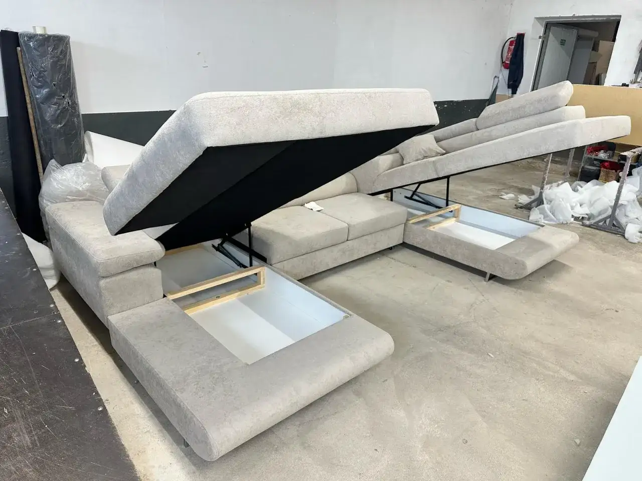 Sofa z systemem rozkładania delfin, z otwartymi schowkami pod siedziskami.