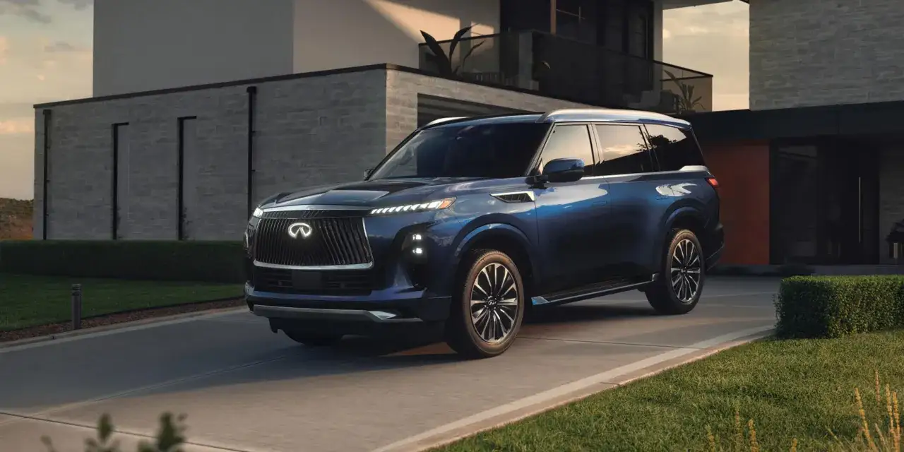 Elegancki, granatowy infiniti samochód parkuje przed nowoczesnym domem.