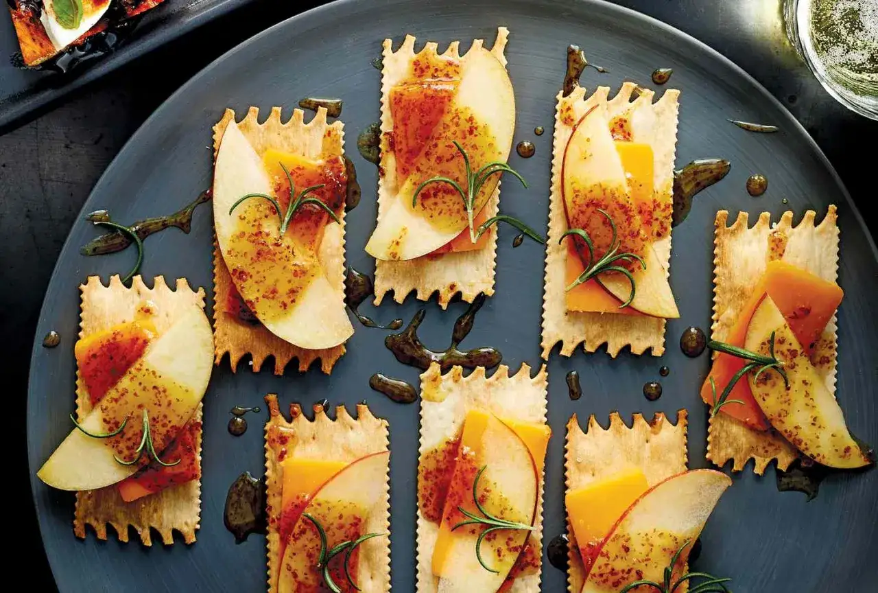 Proste przepisy na przekąski w 15 minut: krakersy z jabłkiem, serem i rozmarynem, polane sosem.