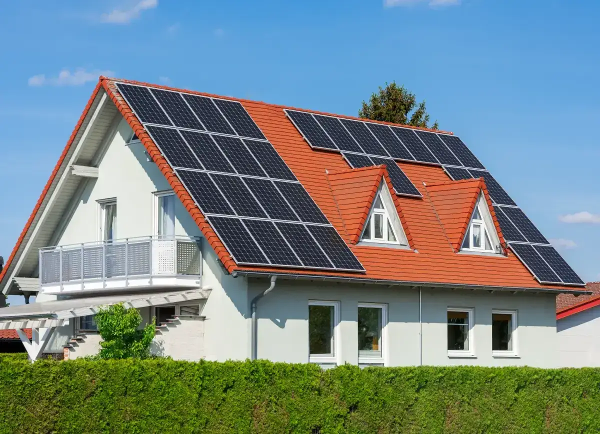 Dom z panelami fotowoltaicznymi na dachu. To pokazuje, co daje fotowoltaika: czystą energię i oszczędności.