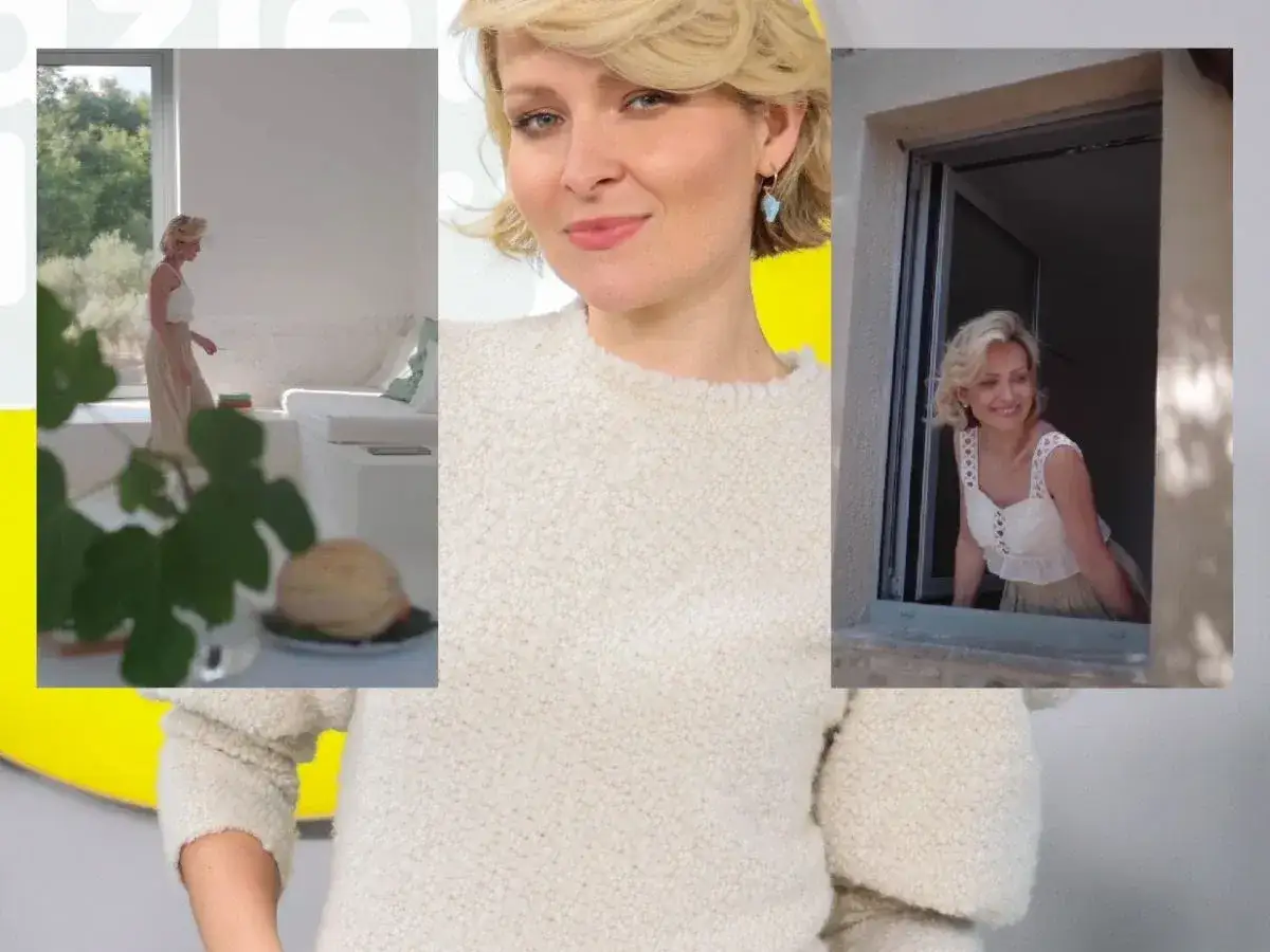 Marieta Żukowska w letniej stylizacji, uśmiechnięta, wygląda przez okno. Może czeka na męża?
