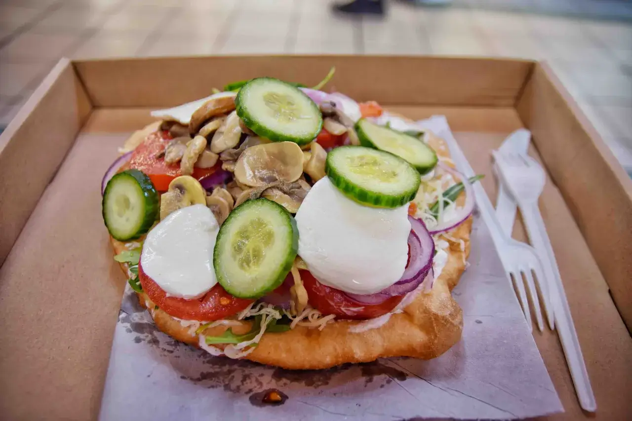 L&aacute;ngos con pomodoro, mozzarella, cetrioli, cipolla rossa e funghi. Un'ottima idea per cosa mangiare a Budapest.