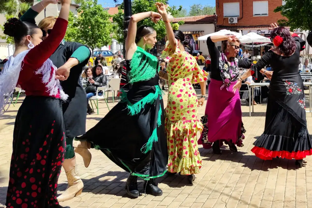 Mujeres con trajes vibrantes bailan flamenco, sus faldas ondean al ritmo de las rumbas para bailar.