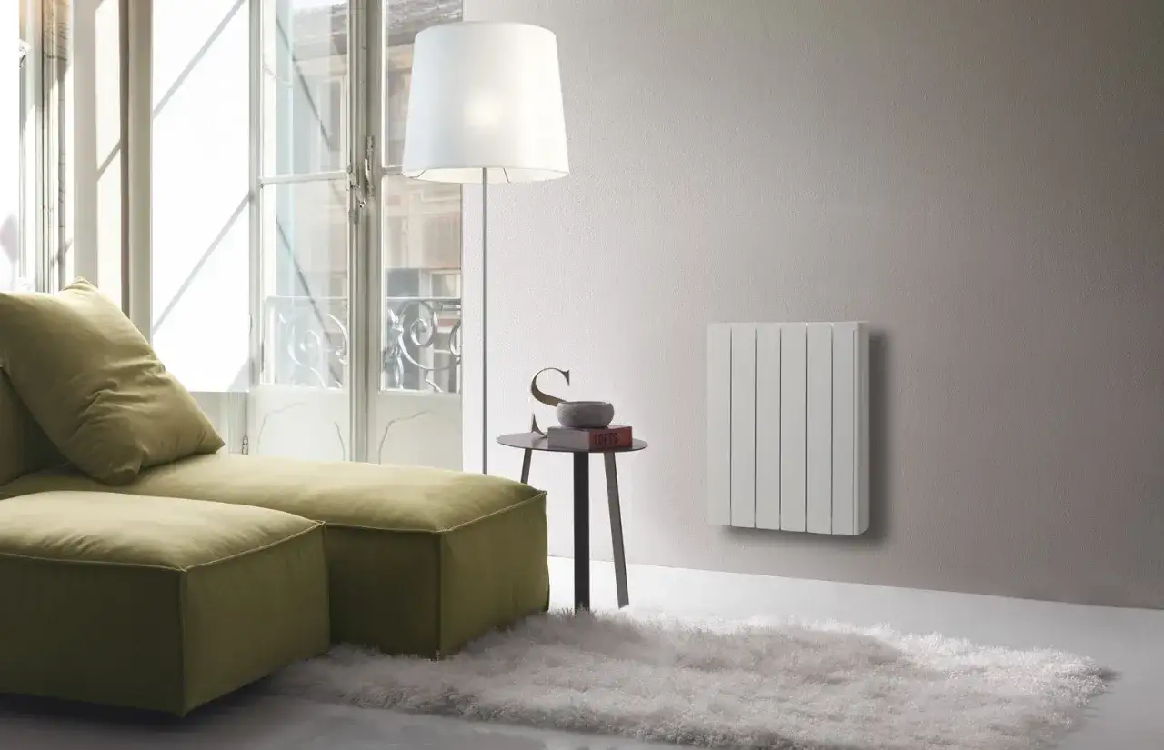 Un moderno soggiorno con divano verde, tappeto soffice e termosifoni svedesi bianchi a parete.