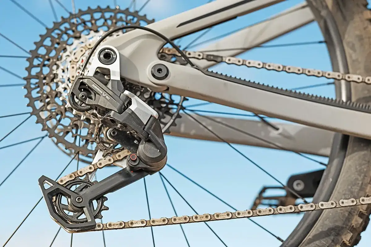 Close-up of a SRAM AXS electronic shifting derailleur on a bicycle's rear cassette and chain.