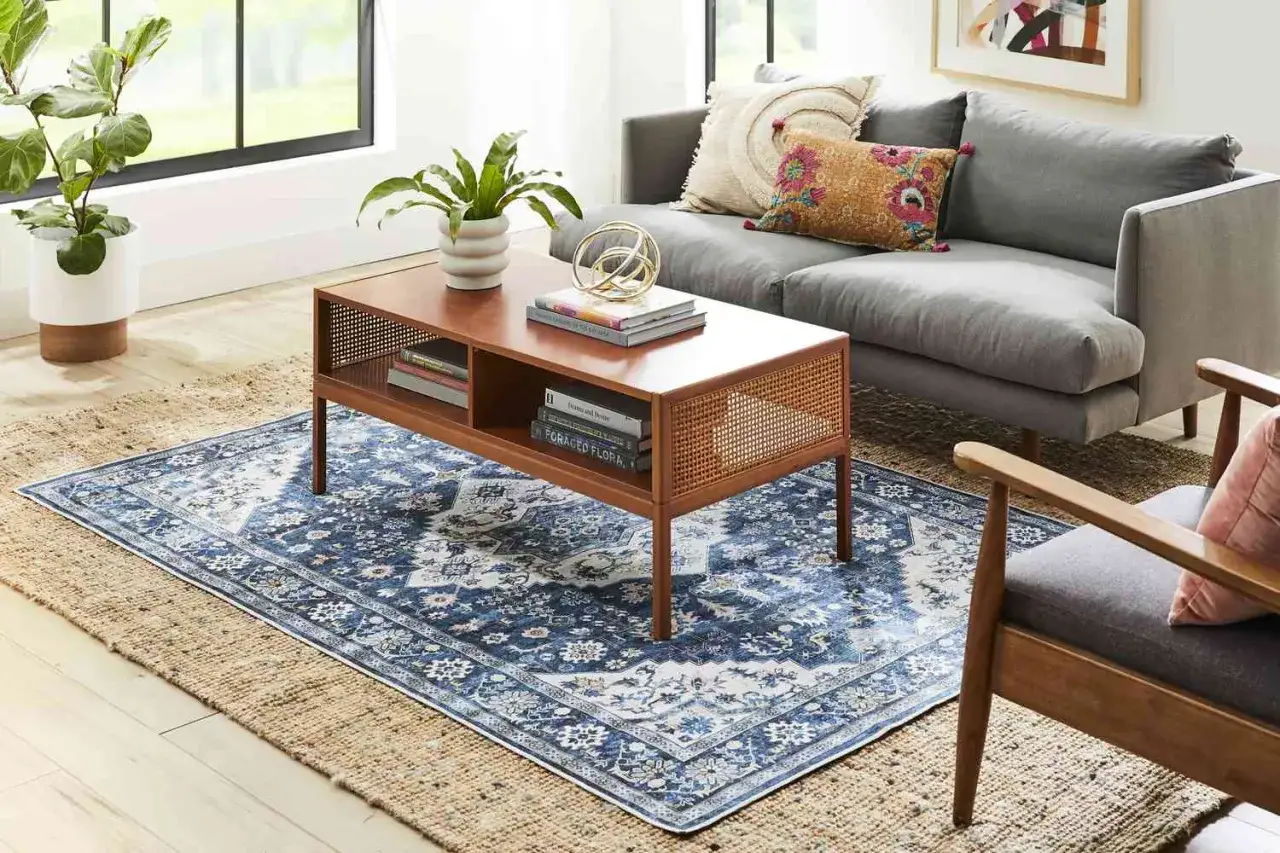 Layering a patterned blue rug over a jute rug creates depth. A 6x9 rug is a good size to layer over an 8x10 rug.