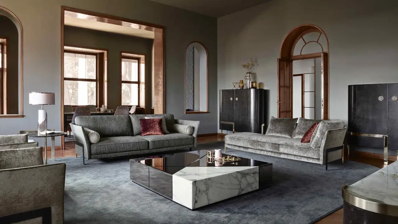 Soggiorno di lusso con divani in velluto, tavolino geometrico in marmo e specchi, che definiscono uno stile contemporaneo casa.