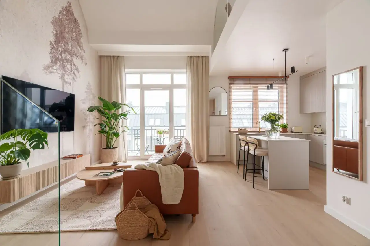 Nowoczesny salon z brązową kanapą, drewnianym stolikiem i tapetą z drzewem. Inspiracja, jak urządzić salon nowocześnie.