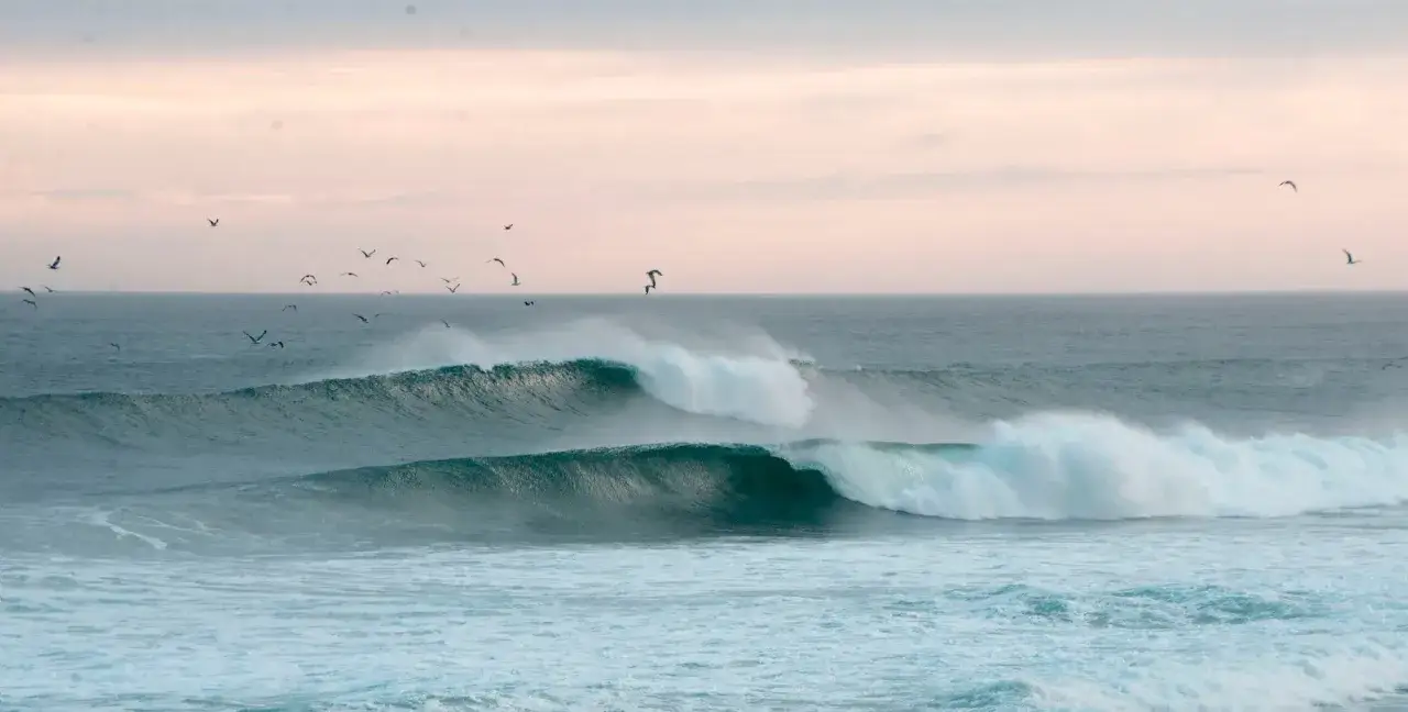 Wellen brechen an der K&uuml;ste Spaniens, M&ouml;wen kreisen &uuml;ber dem Meer. Perfekt f&uuml;r Surfer!