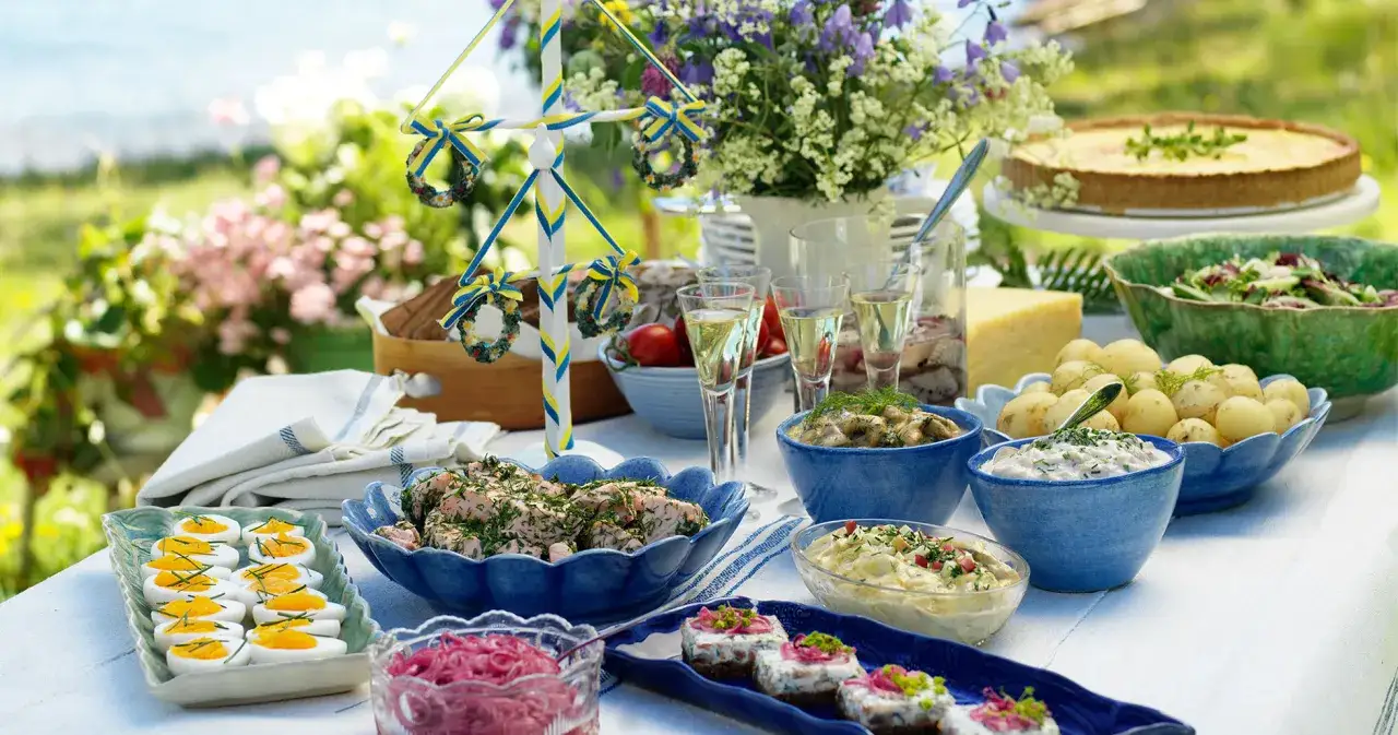 En midsommarbuff&eacute; med sill, &auml;gg, potatis, paj och en majst&aring;ng. Sm&aring; snittar midsommar f&ouml;rgyller dukningen.