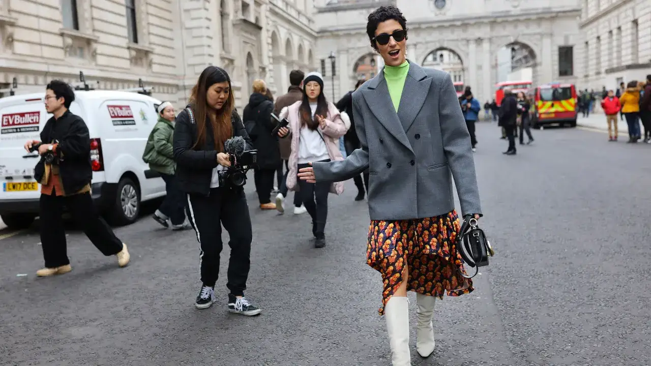 Kobieta w neonowym golfie i kwiecistej sukience prezentuje odważne stylizacje z marynarką oversize.