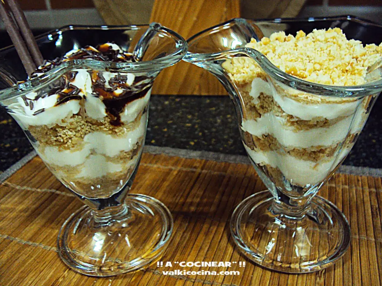 Dos copas de **serradura portuguesa** con capas de galleta triturada y crema, una con sirope de chocolate y virutas, la otra con más galleta.