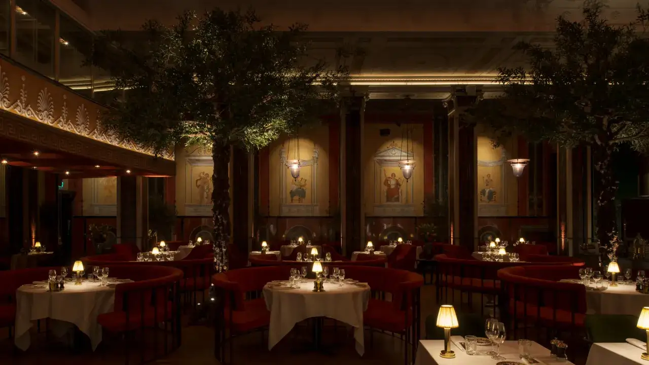 Elegant restaurang med romerska fresker, olivträd och röda sammetssoffor. En perfekt plats för en minnesvärd 