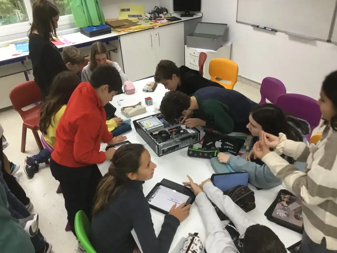Estudiantes de secundaria desmontan un ordenador, fomentando el aprendizaje práctico y la resolución de problemas en situaciones de aprendizaje secundaria.