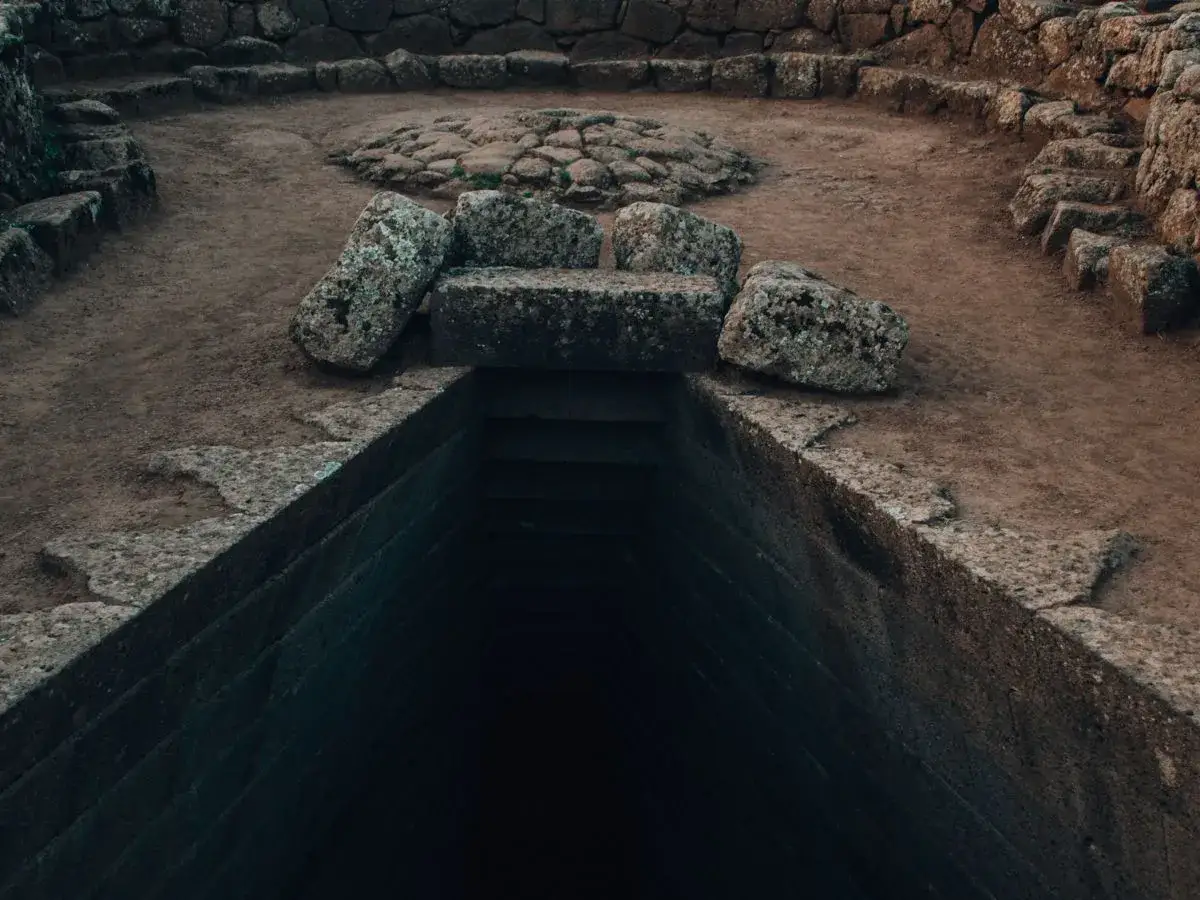 Pozzo sacro di Santa Cristina a Paulilatino, con gradini in pietra che scendono nell'oscurità.