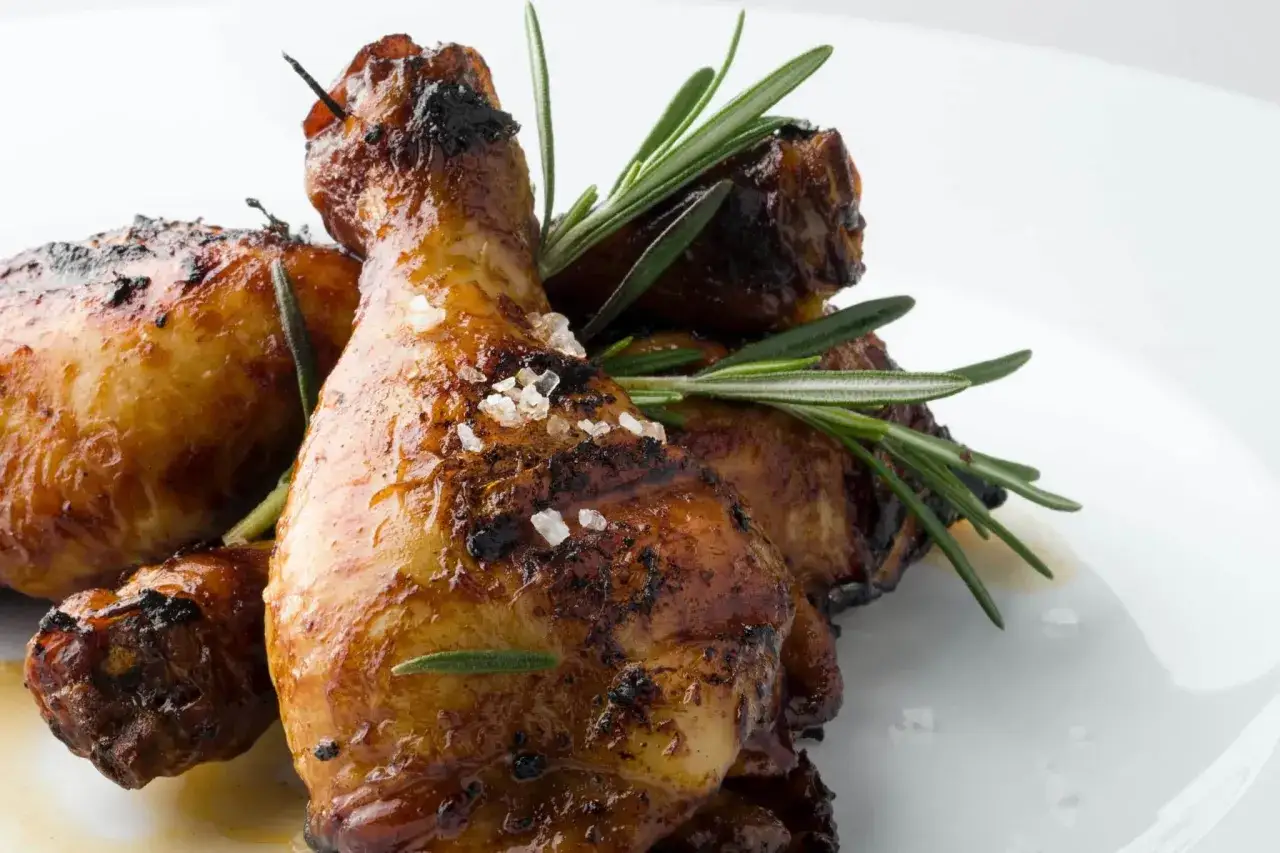 Un délicieux poulet rôti, doré et croustillant, garni de romarin frais et de gros sel, prêt à être dégusté.