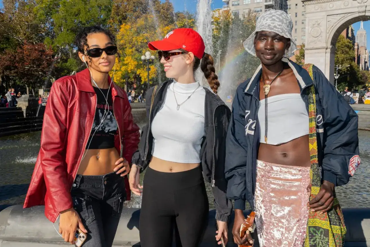 Trzy osoby prezentują styl gen z fashion: czerwona kurtka, biały top, czarne spodnie, czerwona czapka, biały top, czarne legginsy, niebieska kurtka, biały top, różowa spódnica.