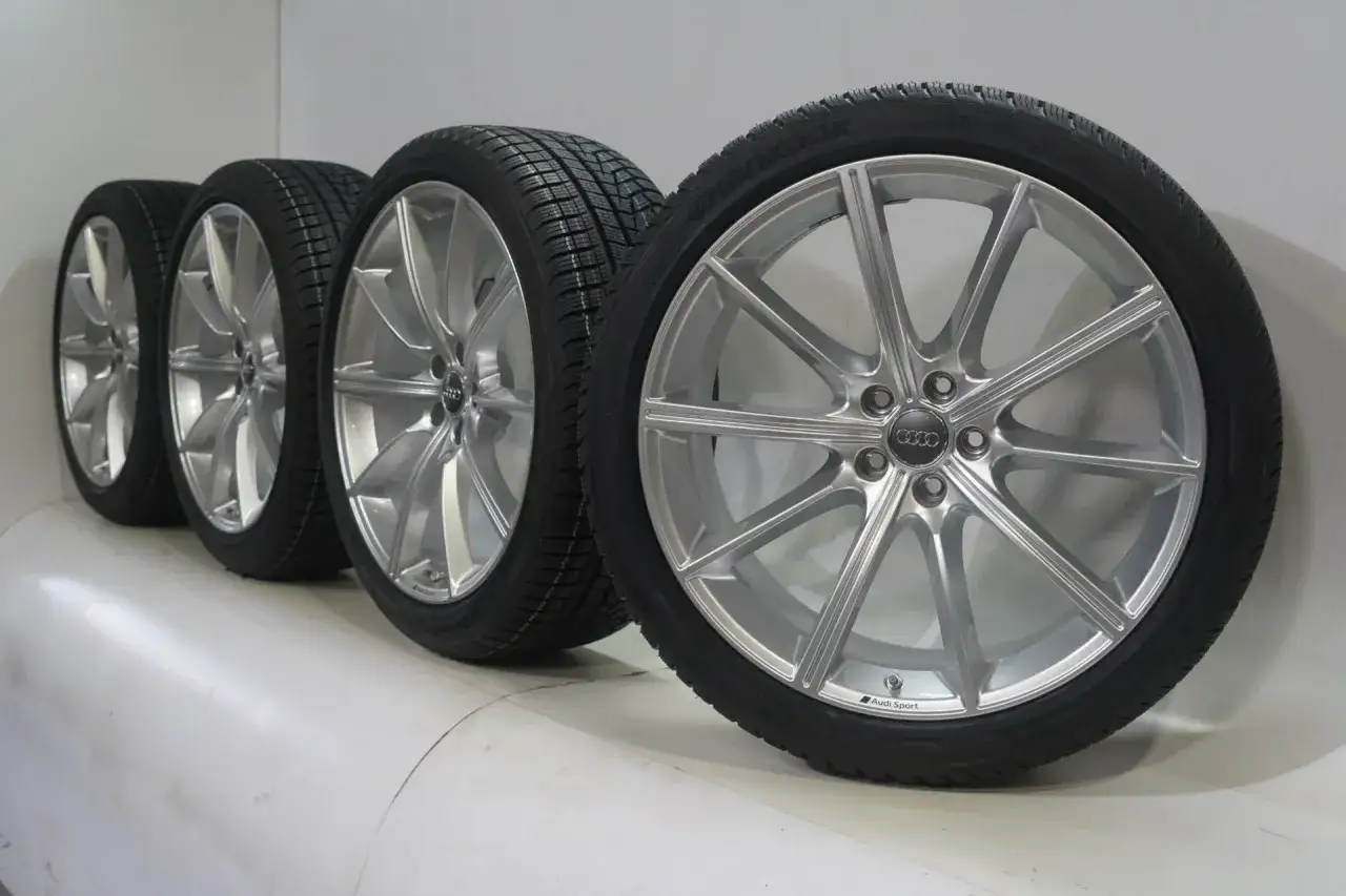 Quattro cerchi in lega argentati con pneumatici invernali, pronti per la tua Audi RS6.