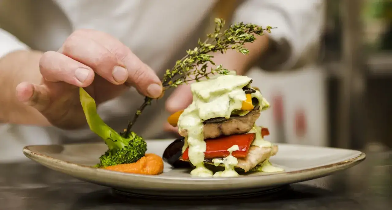 Chef decora un plato con br&oacute;coli y hierbas. &iquest;Robuchon qu&eacute; es? Un arte culinario.