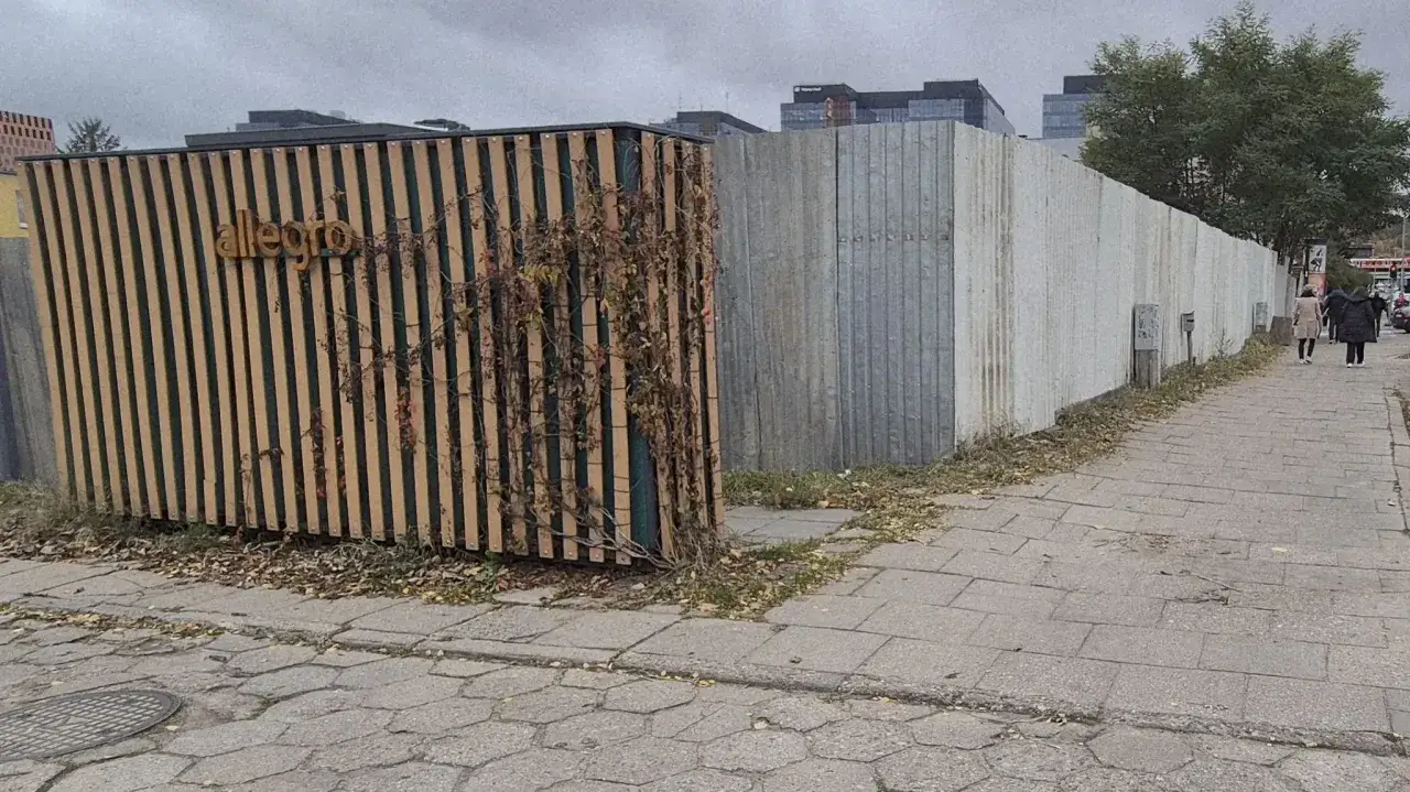 Drewniane i metalowe ogrodzenie z napisem 
