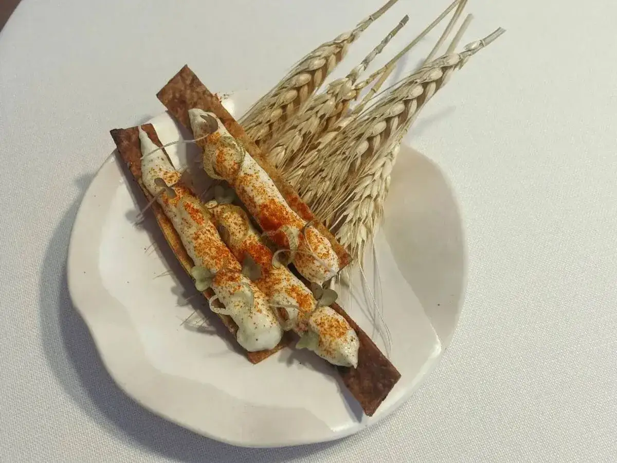 Delicioso aperitivo con crema y pimentón sobre galleta, acompañado de espigas de trigo. ¿Cuántas estrellas Michelin se pueden tener con esta presentación?