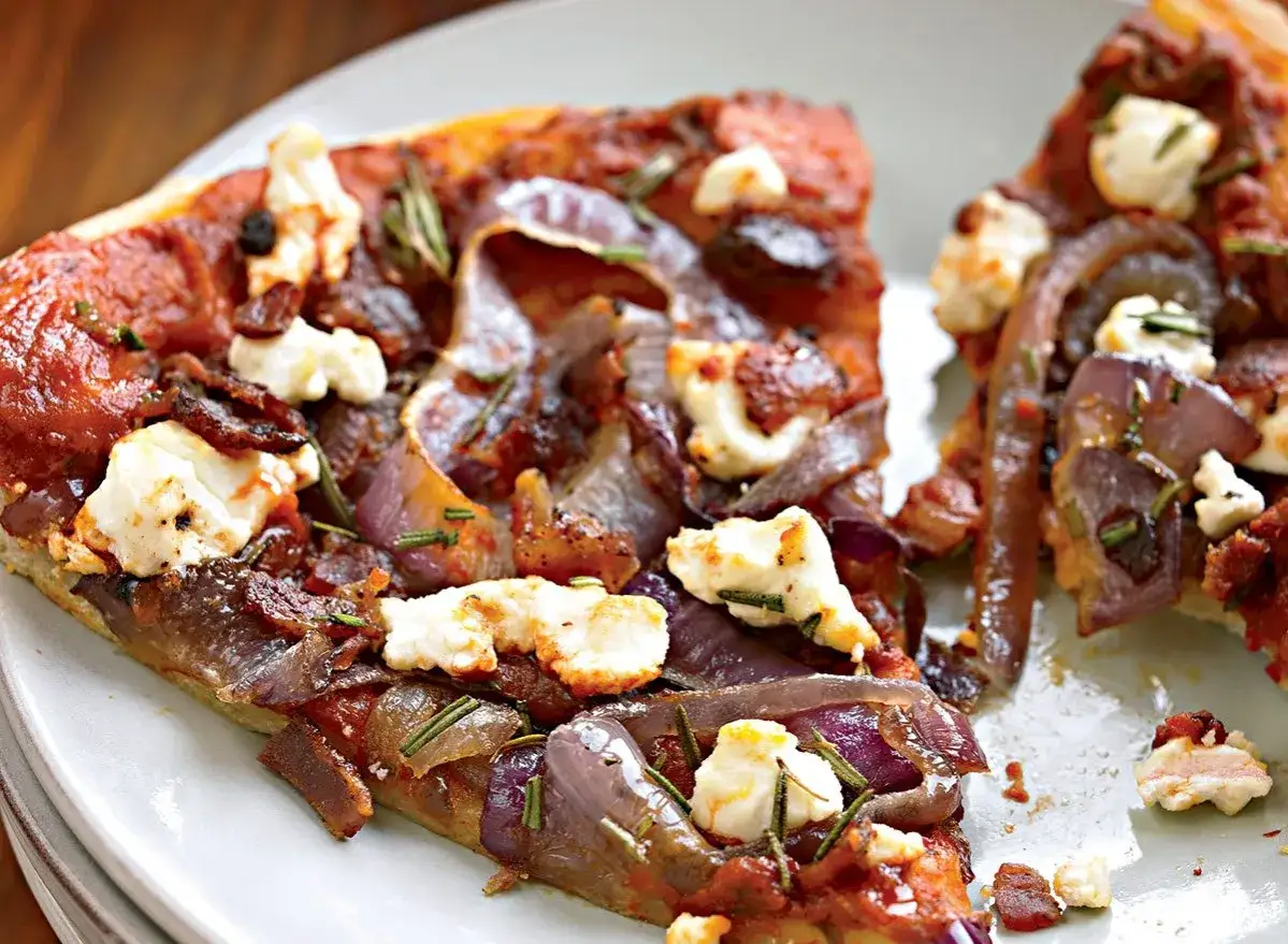 En läcker pizza med bacon, karamelliserad lök och smulad fetaost, toppad med färsk rosmarin.
