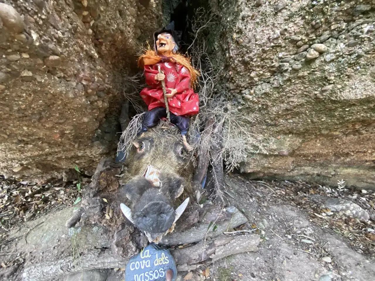 Una bruja sentada sobre un jabal&iacute; disecado en el Bosc de les Bruixes. La cueva de los narices.