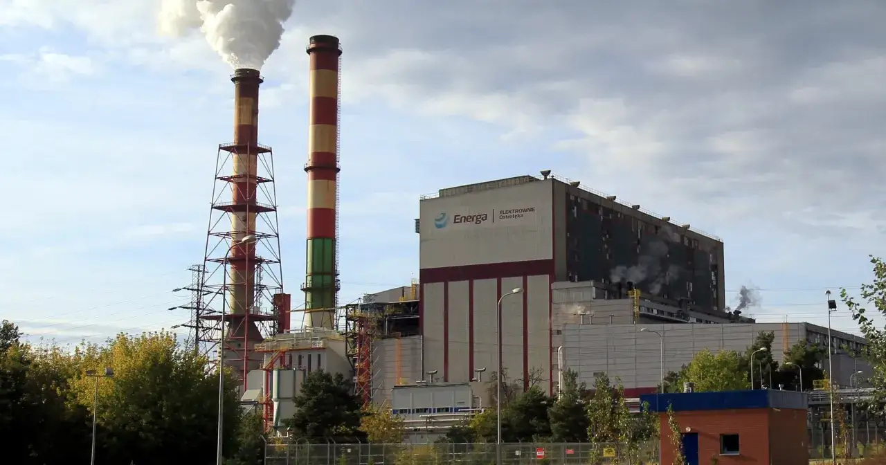 Dwa wysokie kominy elektrowni Energa Ostrołęka wydzielają dym.