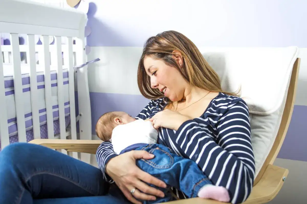 Mama karmi dziecko w wygodnym, bujanym fotelu. Idealny fotel do karmienia, kt&oacute;ry zapewnia komfort i bliskość.