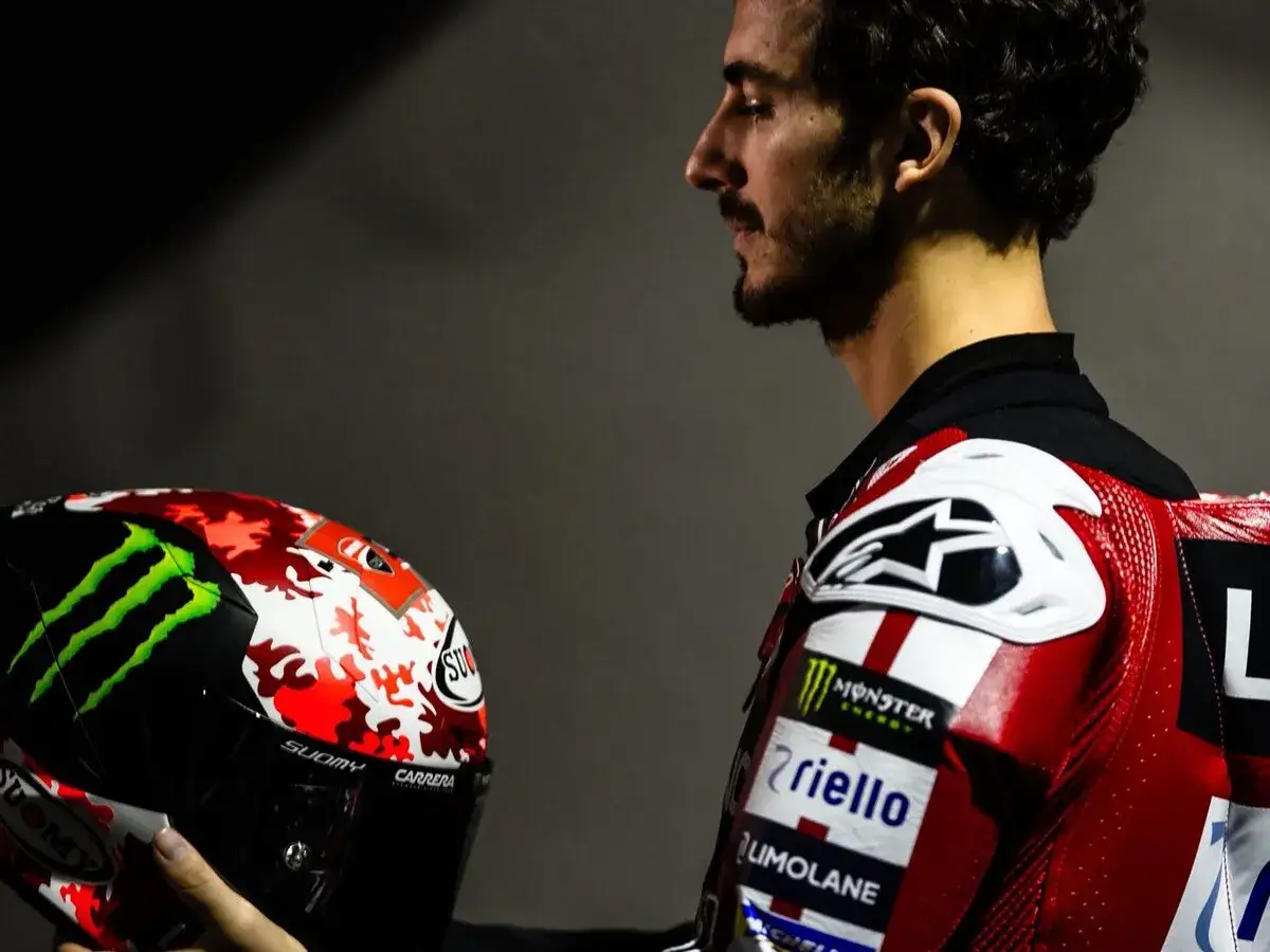 Pecco Bagnaia hoy, con su casco de diseño llamativo y su traje de piloto rojo, listo para la acción.